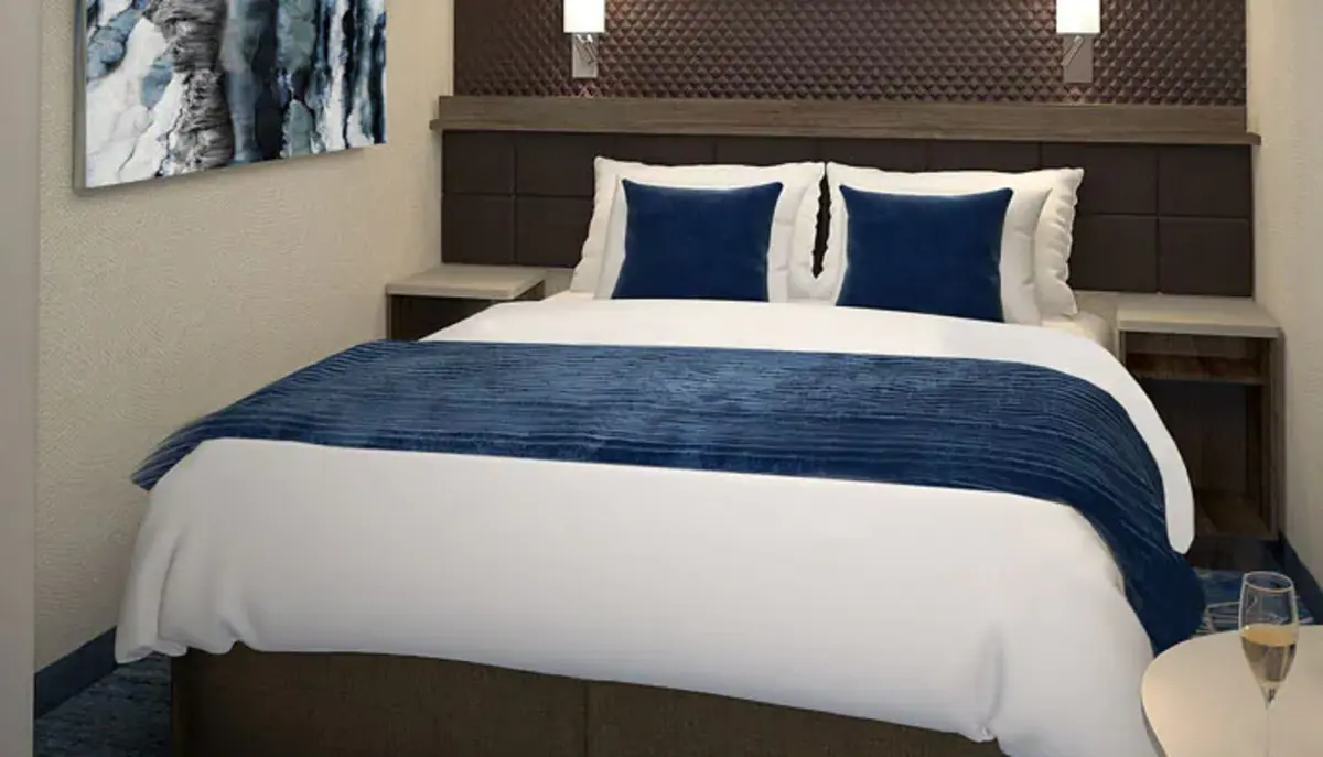 Inside stateroom, queen bed in navy and white