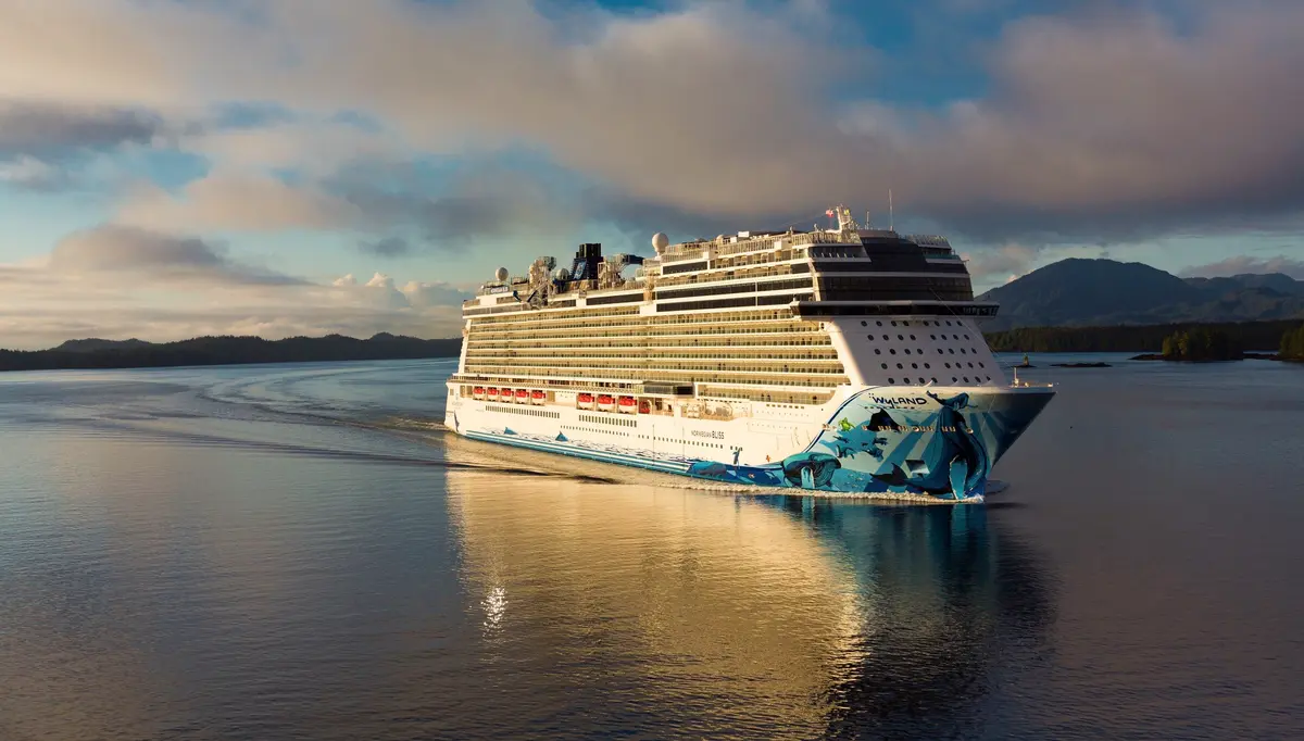 Norwegian Bliss under way at golden hour, her whale hull art catching the light
